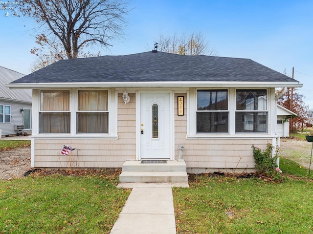 bungalow-style home with a front yard