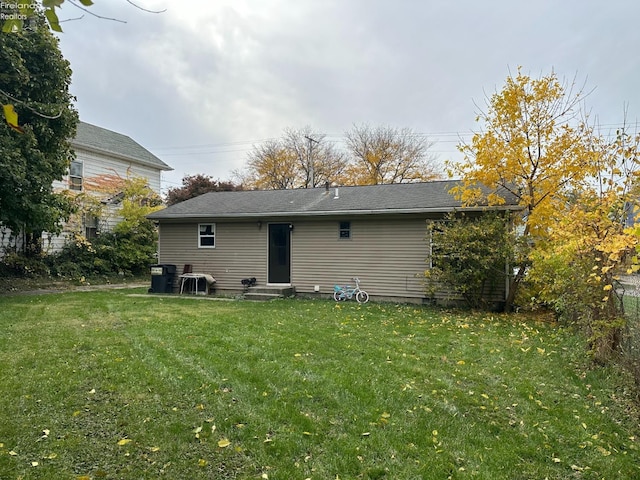 rear view of property featuring a lawn