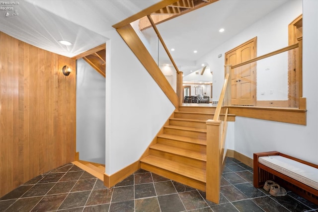 stairs featuring wooden walls