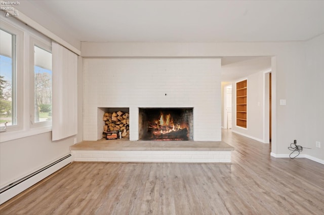 unfurnished living room featuring a fireplace, hardwood / wood-style floors, and a baseboard heating unit