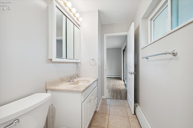 bathroom with toilet, vanity, a baseboard radiator, and tile patterned floors