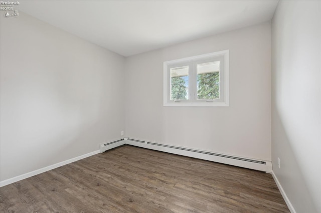 spare room featuring dark hardwood / wood-style floors and a baseboard radiator