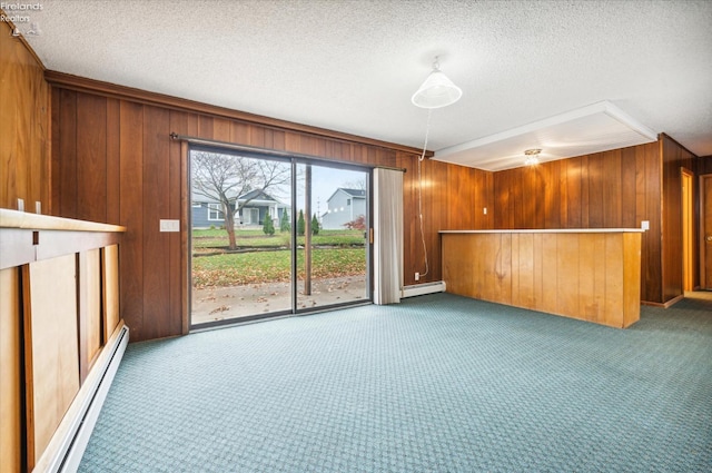 unfurnished living room with carpet flooring, baseboard heating, and wood walls