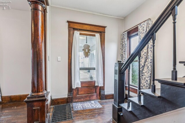 entryway featuring dark hardwood / wood-style flooring, decorative columns, and plenty of natural light