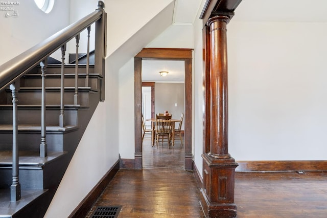 stairway featuring ornate columns and hardwood / wood-style flooring