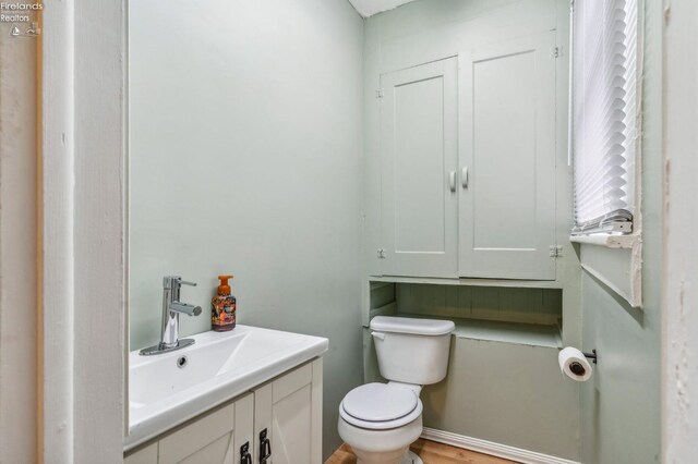 bathroom featuring hardwood / wood-style flooring, vanity, and toilet