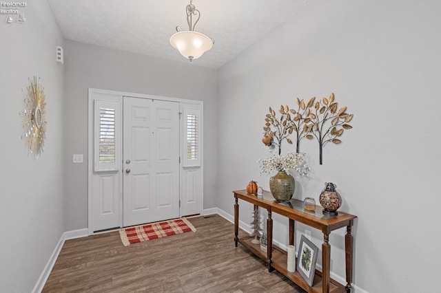 foyer entrance with hardwood / wood-style floors and a textured ceiling