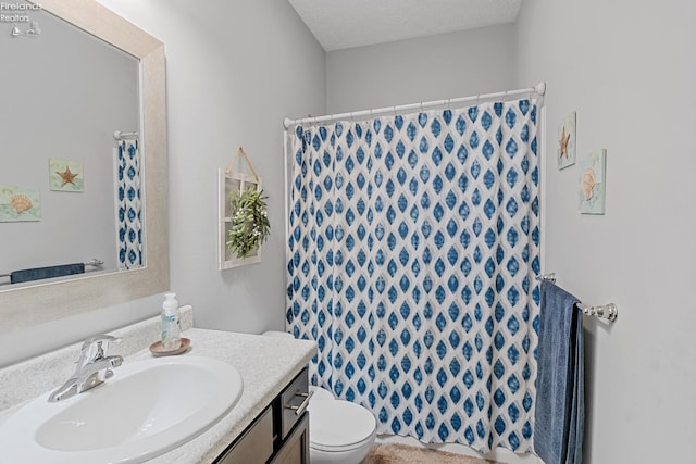 bathroom featuring vanity, a shower with shower curtain, a textured ceiling, and toilet