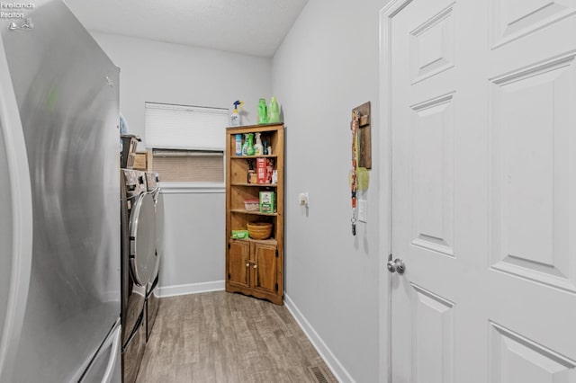2133 S Harbor Bay Dr, Marblehead, OH 43440 - laundry area with washing machine and dryer, light wood-style floors, baseboards, and a textured ceiling