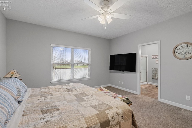 bedroom with ceiling fan, carpet floors, and a textured ceiling