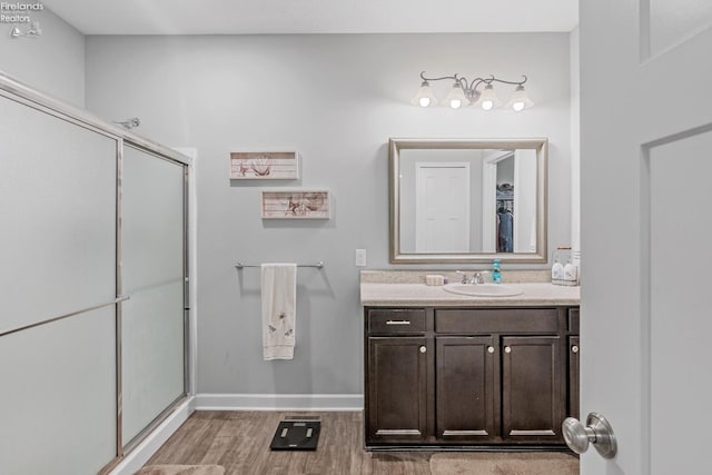 bathroom with wood-type flooring, vanity, and walk in shower