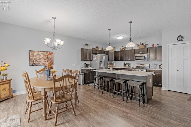 dining room featuring an inviting chandelier, a textured ceiling, and hardwood / wood-style flooring