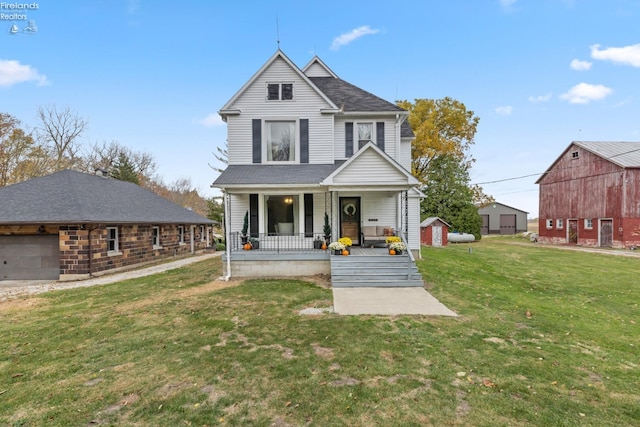 view of front of home with a porch, a front lawn, and an outdoor structure