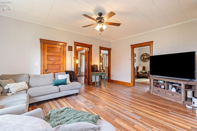 living room featuring ceiling fan, ornamental molding, and light hardwood / wood-style flooring