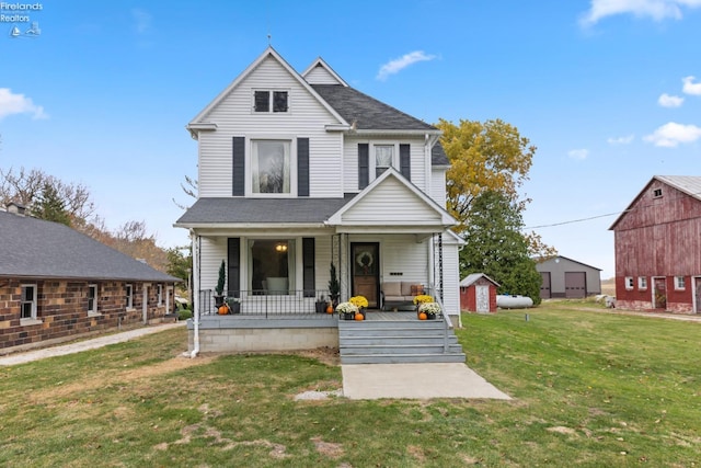 view of front of home with covered porch, a front lawn, and an outdoor structure