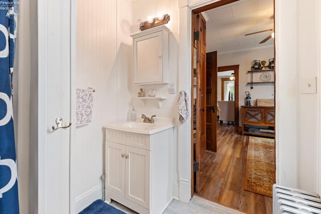 bathroom featuring radiator heating unit, vanity, hardwood / wood-style flooring, and ceiling fan