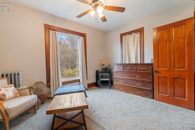 living area with carpet flooring, radiator, and ceiling fan