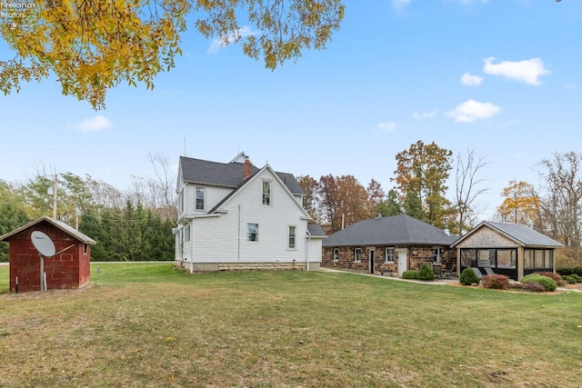 rear view of property featuring an outbuilding and a yard