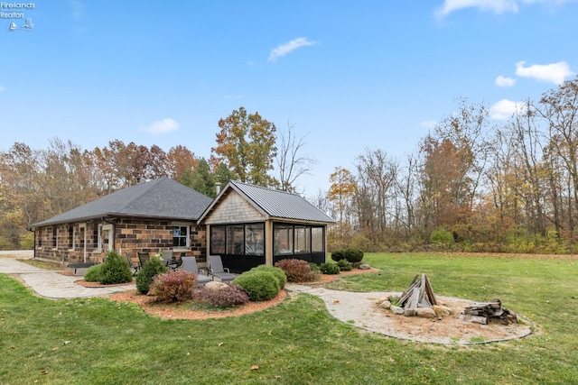 rear view of property featuring a lawn and a sunroom