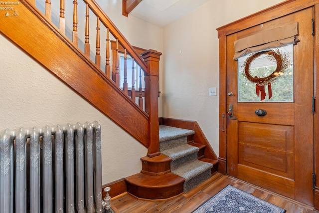 entryway with radiator and hardwood / wood-style flooring