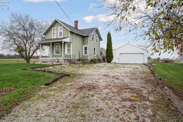 view of front of home with an outbuilding, a garage, a front lawn, and covered porch