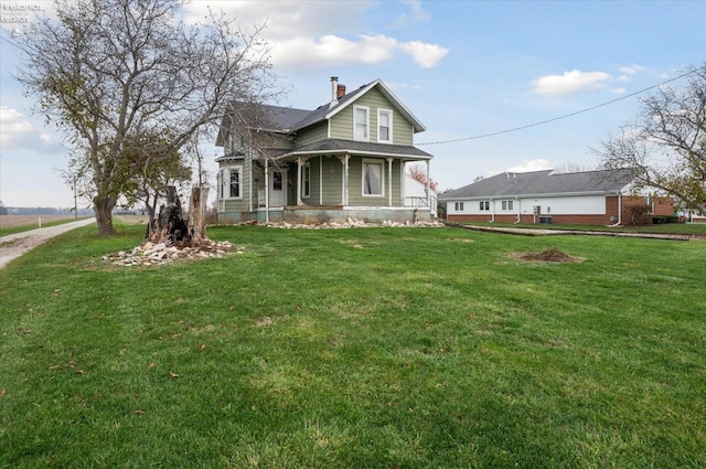 view of front of house featuring covered porch and a front yard