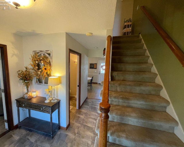 stairway with a textured ceiling