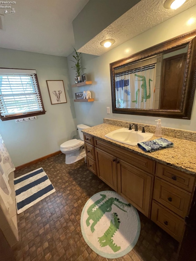 bathroom featuring a shower with shower curtain, a textured ceiling, vanity, and toilet