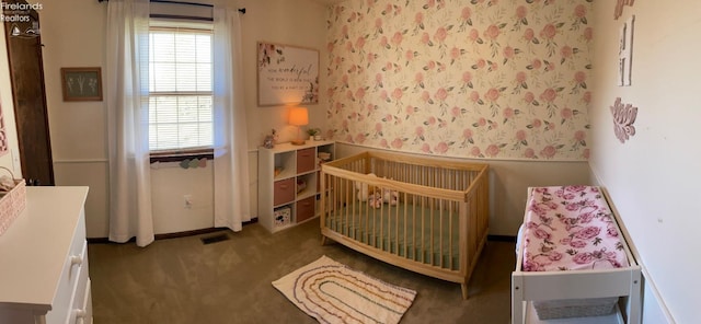 bedroom featuring carpet and a nursery area