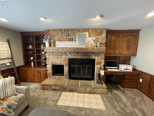 living room featuring a textured ceiling, light colored carpet, a fireplace, and wooden walls