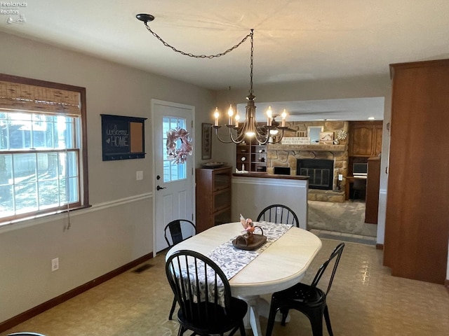 dining area with a fireplace and a chandelier