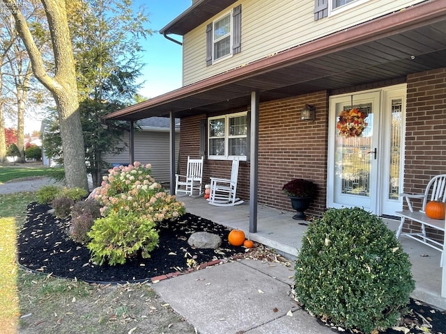 view of exterior entry featuring covered porch