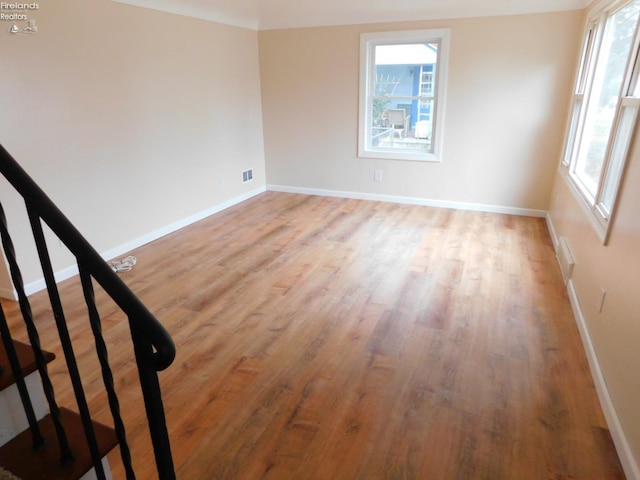 spare room with a wealth of natural light and light wood-type flooring