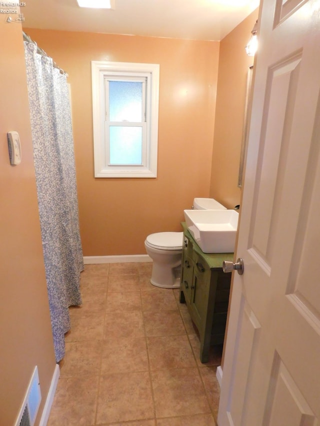 bathroom with tile patterned flooring, vanity, and toilet