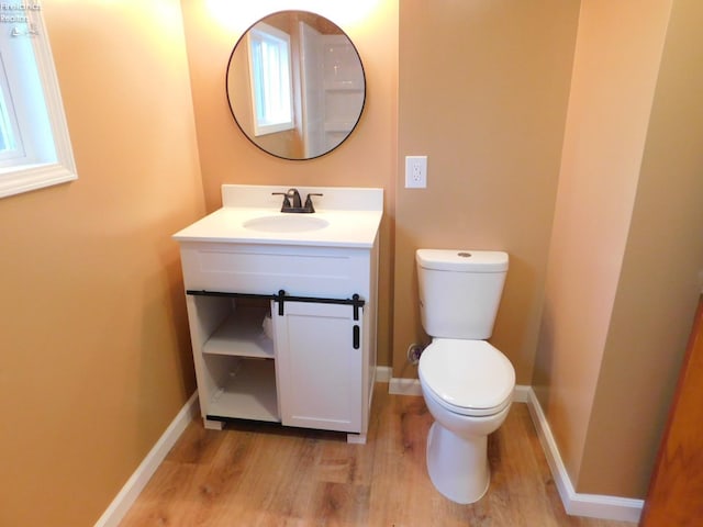 bathroom with hardwood / wood-style floors, vanity, and toilet