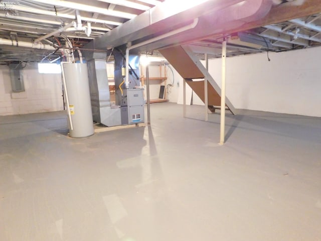 basement with electric panel, heating unit, and water heater