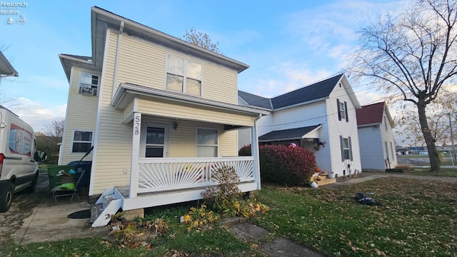 back of property featuring covered porch