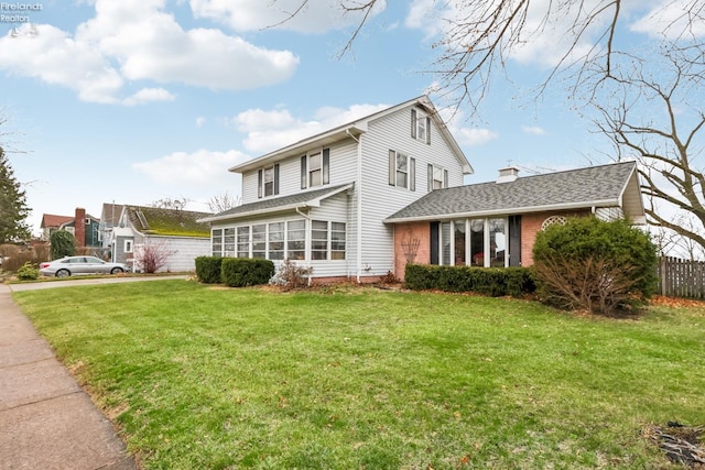 back of property with a sunroom and a yard