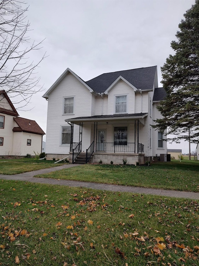 view of front of home with a front yard, central air condition unit, and covered porch