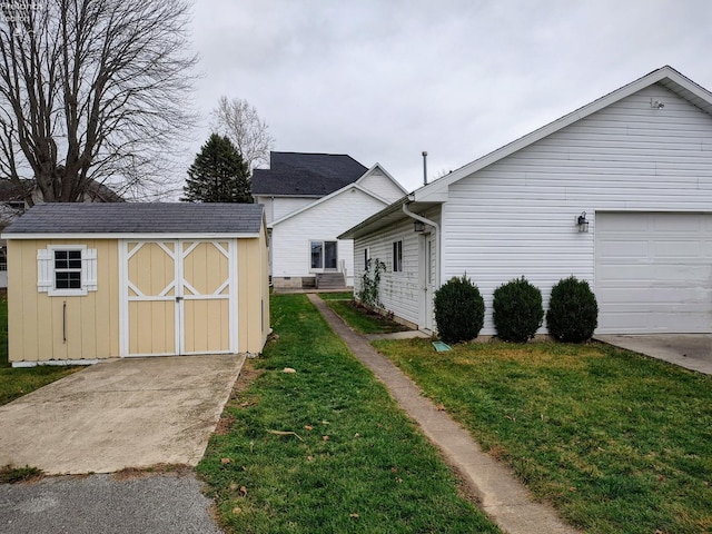 exterior space featuring a yard, a garage, and a storage unit