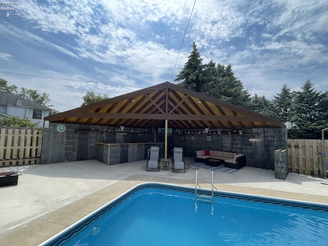 view of pool with a gazebo, an outdoor living space, and a patio