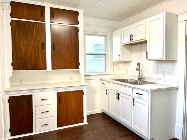 kitchen featuring wood walls, sink, dark hardwood / wood-style floors, ornamental molding, and white cabinetry