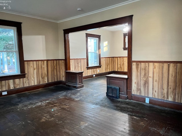 unfurnished room with crown molding, dark wood-type flooring, and wood walls