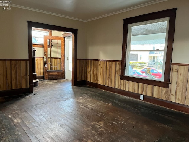 spare room with wooden walls, dark hardwood / wood-style floors, and crown molding