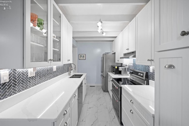 kitchen with white cabinets, sink, appliances with stainless steel finishes, beam ceiling, and light stone counters