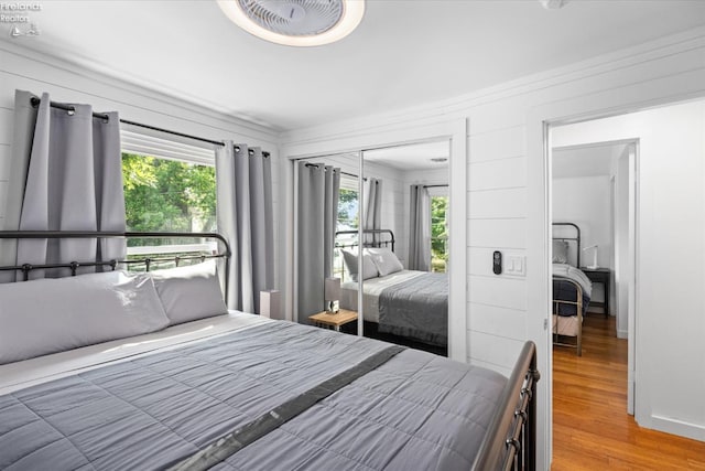 bedroom with hardwood / wood-style flooring, a closet, and crown molding