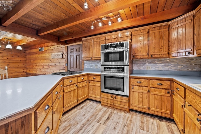 kitchen featuring appliances with stainless steel finishes, light hardwood / wood-style floors, tasteful backsplash, and wooden walls