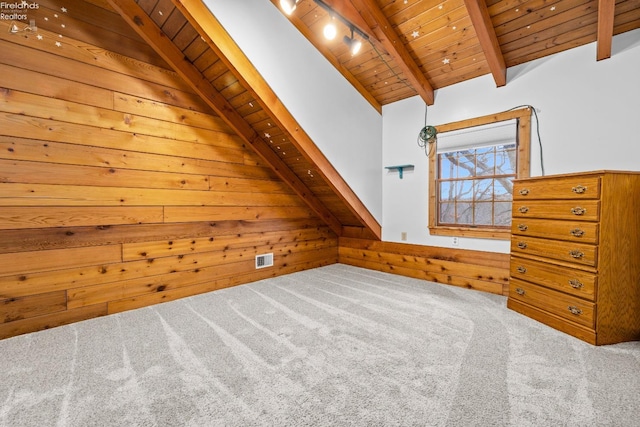 additional living space with carpet flooring, vaulted ceiling with beams, wood walls, and wooden ceiling