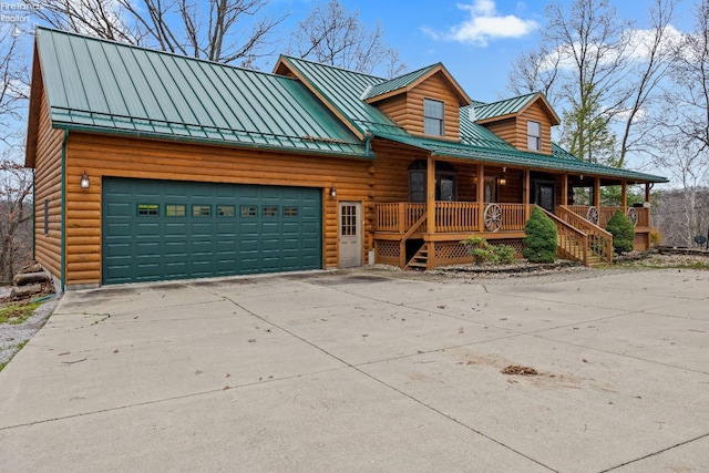 cabin with covered porch and a garage