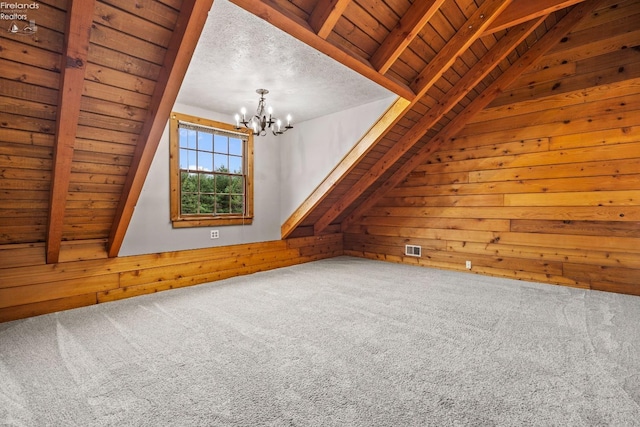 additional living space with carpet flooring, wood walls, wood ceiling, and an inviting chandelier